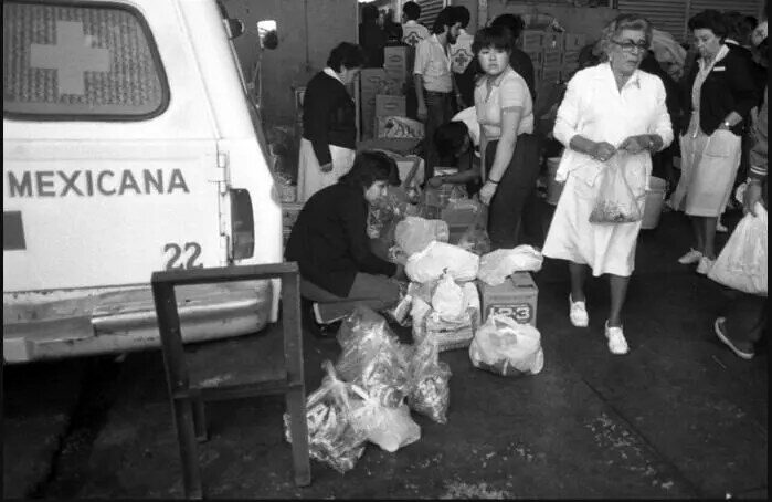 Voluntarias y personal de la Cruz Roja Mexicana preparan víveres junto a una ambulancia tras la explosión de San Juanico.